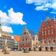 View of the Old Town Ratslaukums square, Roland Statue, The Blackheads House and St Peters Cathedral against blue sky in Riga, Latvia. Summer sunny day.