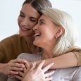 Close up image beautiful faces of happy european women different generations indoors, adult 30s daughter hugs elderly mother people enjoy tender moment, cuddle as symbol of deep connection, true love