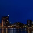 Illuminated Bridge And City Skyline With Still Water Reflections In Finland