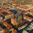 A drone shot captures Koszalin city center bathed in golden light, featuring the cathedral, Victory Street, and town hall.